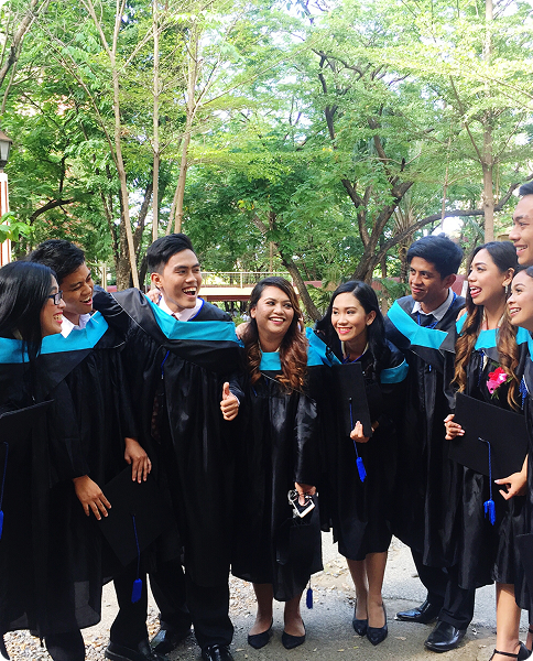 Group of graduates celebrating in caps and gowns, achieving their goal.